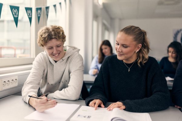 Två elever i ett klassrum arbetar med en gruppuppgift