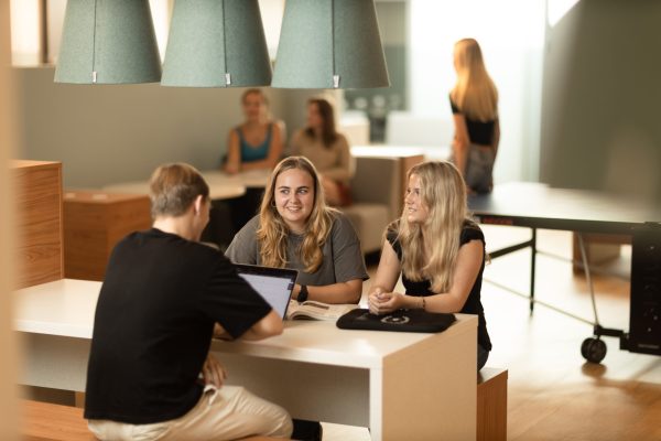 Tre elver sitter i skolans gemensamma lokaler.