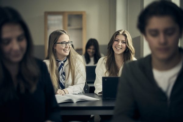 Två glada elever i klassrum.