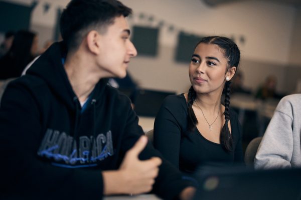 Två elever i ett klassrum tittar på varandra