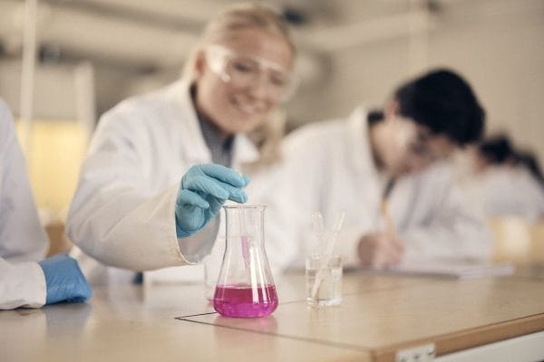 Två elever i labbrock studerar molekylmodeller i ett laboratorium.