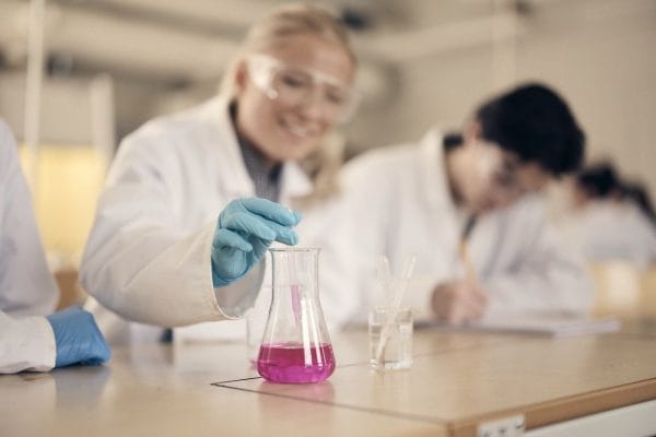 Två elever i labbrock studerar molekylmodeller i ett laboratorium.