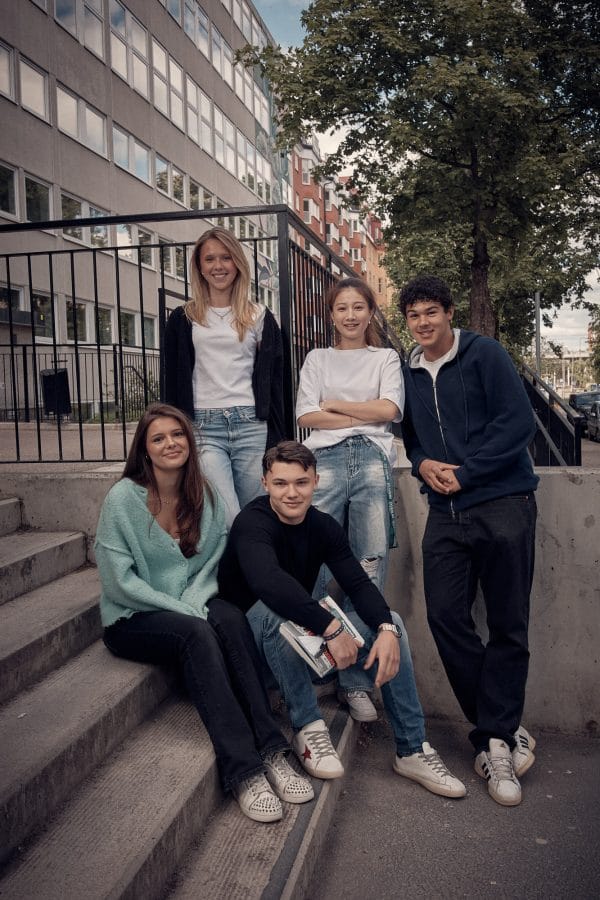 Fem glada elever utanför Campus Vasastan.